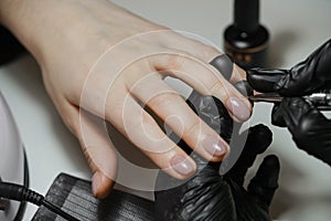 Nail service. Cropped view of the girl getting her nails done at the salon photo