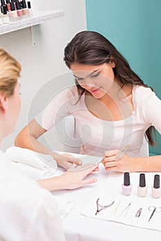 Nail technician giving customer a manicure