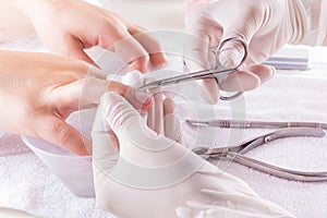 Nail technician giving customer a manicure at nail salon. Young caucasian woman receiving a french manicure. Closeup shot of a