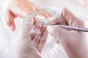 Nail technician giving customer a manicure at nail salon. Young caucasian woman receiving a french manicure. Closeup shot of a