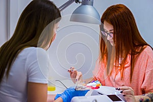 Nail technician shows the color palette of nail services in beau