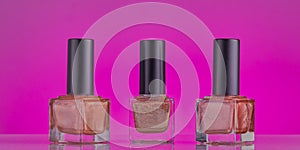 Nail varnishes on a pink background.