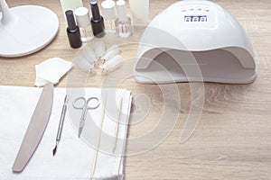 Nail work place White lamp on white table with nail tool . Work place of nail amster with manicure tools.