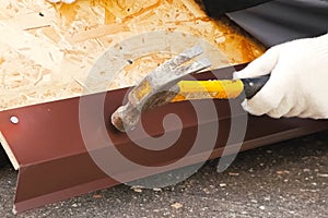 Nailing and hammering sheet of roofing iron