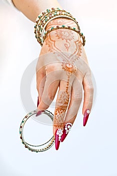 Nails decorated with brilliant and hand with henna tattoos