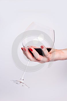 Nails Design. Hands With Bright Red Spring Manicure On Grey Background. Close Up Of Female Hands. Art Nail. Red wine glass