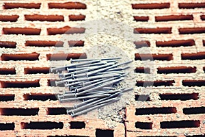 Nails and hammer on construction site, bricks layer and mortar. New building site wallpaper, carpentry and craftsmanship.