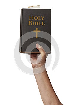 Naked arm raised into the air with hand reaching up holding the Holy Bible book of Chistianity