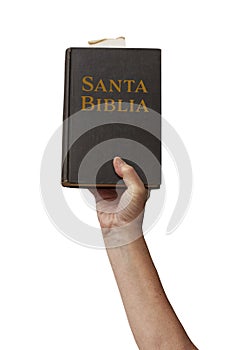 Arm raised into the air with hand reaching up holding the Santa Biblia - Holy Bible in Spanish photo