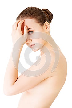 Naked attractive woman touching her forehead.