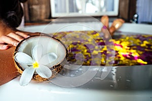 Naked brunette young woman relaxing in bath with petals in tropics. Time for yourself.romantic 14 february valentine day