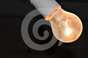 Naked dusty light bulb glows electricity