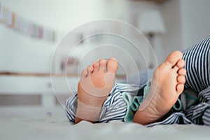 Naked feet of a young girl in bed, morning