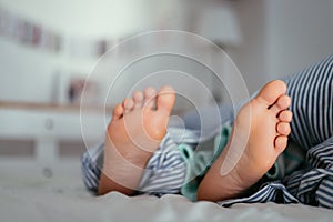 Naked feet of a young girl in bed, morning