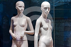 Naked female mannequins in the shop window. Fashion clothing woman mannequin in the store.