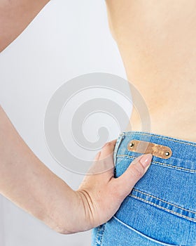 naked female torso, female waist. blue jeans on a beautiful woman. beautiful female figure