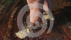 Naked hairy male legs walk on pier. The legs of a man swim. First person of view. Men rest on a flood wood underwater