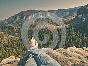 Naked male crossed legs take a rest on rock