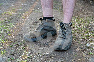 Naked male feet dressed in old shoes