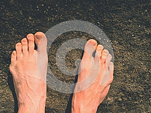 Naked male feet on dry sandstone. Fresh pink skin, shor tnails. Foot on pure nature ground