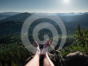 Naked male hairy legs take rest on peak. Outdoor activities in summer