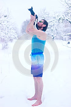 Naked man make some photo in the winter snowy forest