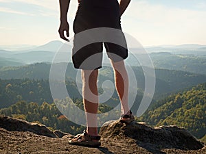 Naked man stay in black pants at the top of mountain. Hiker watch the morning hilly landscape