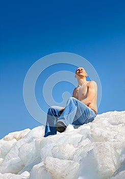 Naked man on top of the ice mountain against