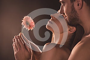 naked sensual lovers holding flower,