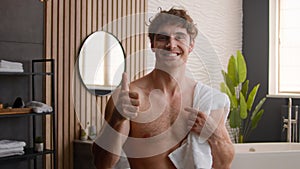 Naked sexy shirtless fit Caucasian happy man in bathroom morning hygiene procedure bath with towel on shoulder smiling