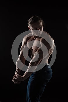 Naked torso male bodybuilder athlete with long blond hair in studio