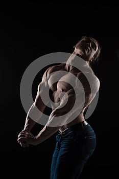 Naked torso male bodybuilder athlete with long blond hair in studio