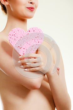 Naked woman holding heart sponge