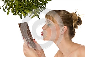 Naked woman kissing chocolate under mistletoe