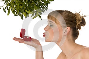 Naked woman kissing a ring under mistletoe