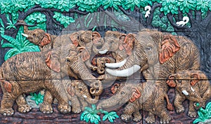 Nakhonnayok, THAILAND - May 3, 2015 : Antique decorate wall : Elephants playing in the forest.