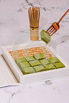 Nama Matcha Chocolate On A White Marble Countertop With Matcha Tea Whisk Chasen