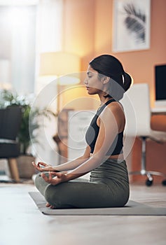 Namastay at home. a beautiful young woman meditating at home.