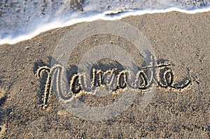 Namaste written in the sand