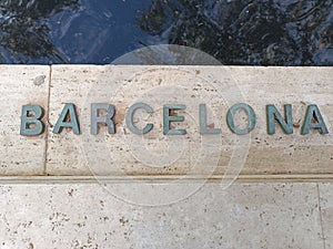 name of Barcelona written in bronze on marble.