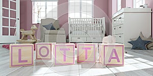 The name lotta written with wooden toy cubes in children`s room
