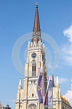 The Name of Mary Church, also known as Novi Sad catholic cathedral on a sunny afternoon with flags of Voivodina province, Serbia