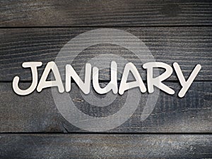 The name of the month is composed of light wooden letters on dark wood. The month of January.
