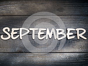 The name of the month is composed of light wooden letters on dark wood. The month of September.