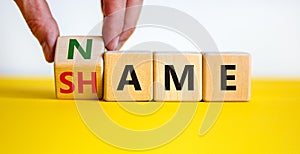 Name or shame symbol. Businessman turns the wooden cube and changes the word `shame` to `name` or vice versa. Beautiful yellow