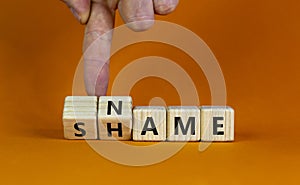 Name or shame symbol. Businessman turns wooden cubes and changes the word `shame` to `name` or vice versa. Beautiful orange