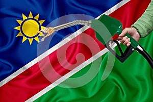 NAMIBIA flag Close-up shot on waving background texture with Fuel pump nozzle in hand. The concept of design solutions. 3d