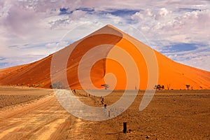 Namibia landscape. Big orange dune with blue sky and clouds, Sossusvlei, Namib desert, Namibia, Southern Africa. Red sand, biggest