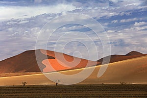 Namibia landscape. Big orange dune with blue sky and clouds, Sossusvlei, Namib desert, Namibia, Southern Africa. Red sand, biggest