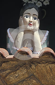 A Namoradeira, lover seraching wooden girl, on a window of Tiradentes, Minas Gerais, Brazil.